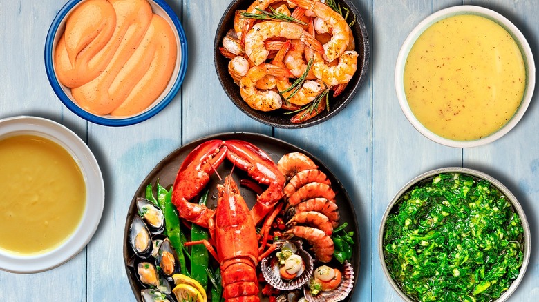 Types of seafood on plates surrounded by various sauces