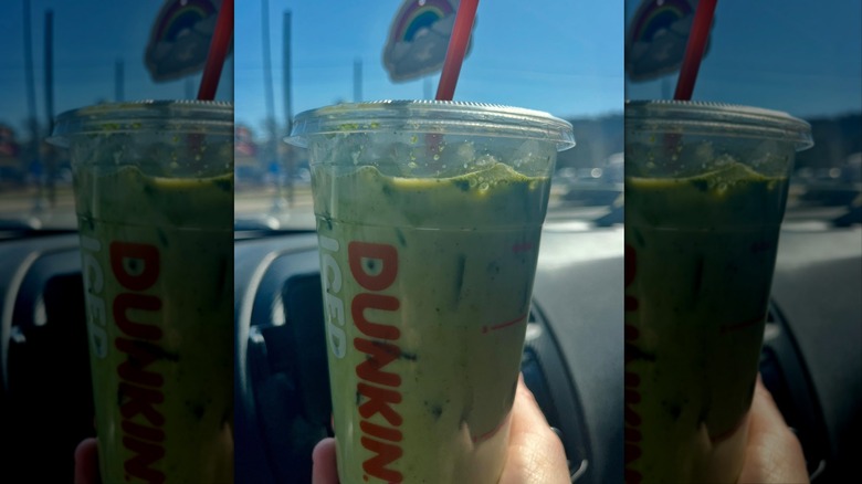 Hand holding Dunkin' Brown Sugar Oat Iced Matcha Latte