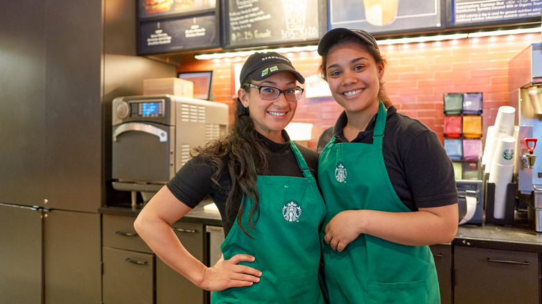Smiling Starbucks baristas in cafe