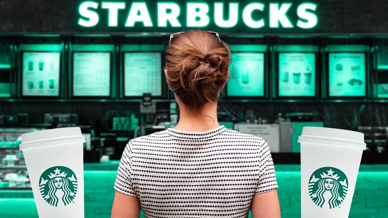 Person standing outside of a green-filtered Starbucks backdrop, next to two to-go cups