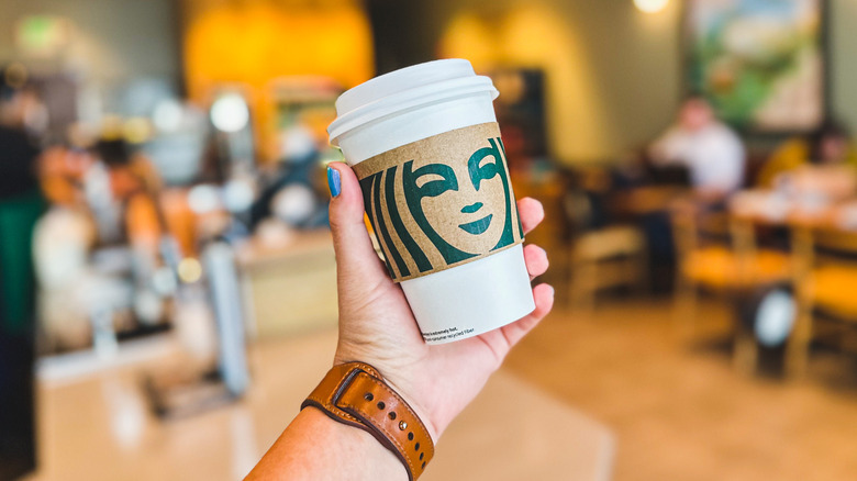 Person holding hot Starbucks drink