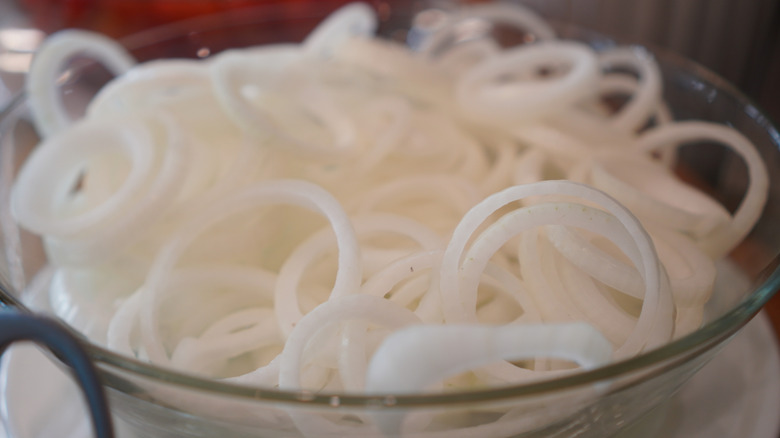Sliced white onions in glass bowl