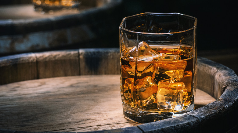 Glass of whiskey on barrel
