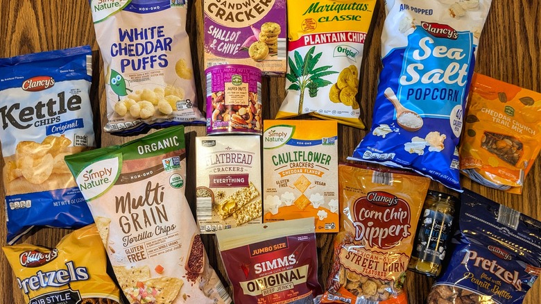 Assorted salty snacks from Aldi spread out on wood table