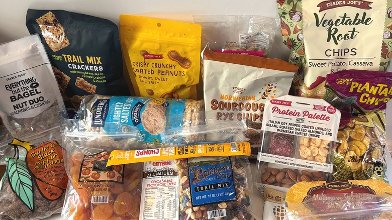 An assortment of cheap, healthy Trader Joe's snacks are on a white table.