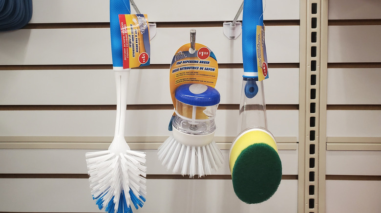 Three dish scrub brushes hanging on the rack at Dollar Tree