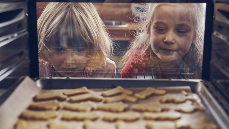 Children watching cookies baking