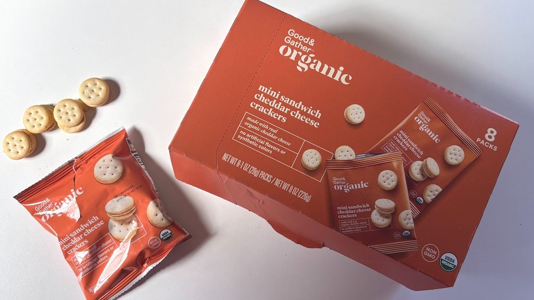 Box of Good & Gather Organic Mini Sandwich Cheddar Cheese Crackers next to an open package on a white table