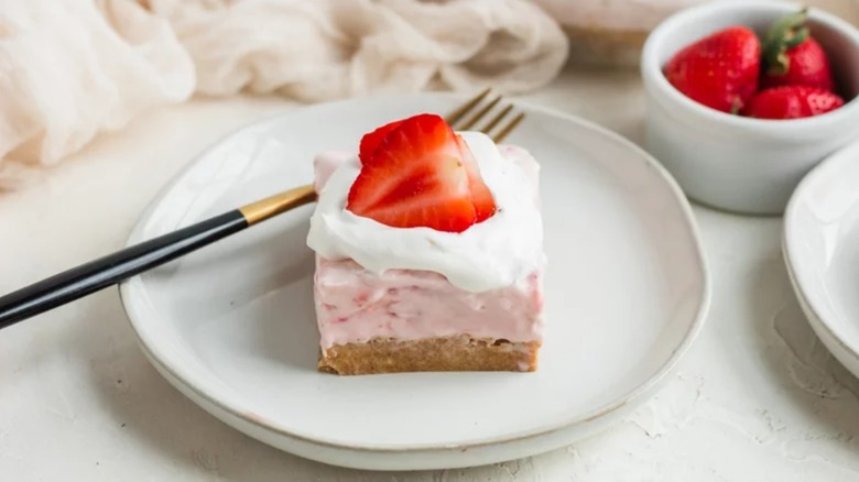 A strawberry cheesecake bar on a plate