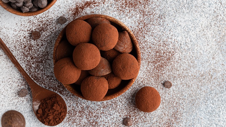 Pile of dark chocolates sprinkled cocoa powder