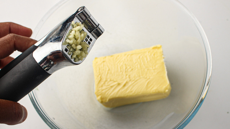 a garlic press over butter