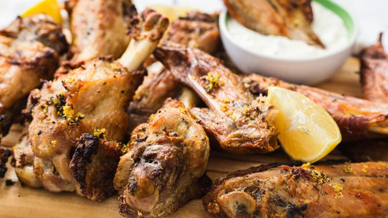 Lemon pepper turkey wings stacked on top of each other with lemon