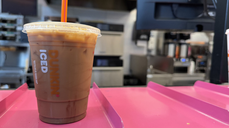 Dunkin cold brew with lava cake flavor swirl on a pink counter ready for pickup.