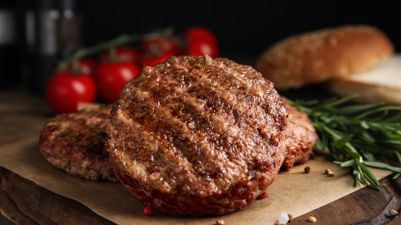Cooked burger pattys stacked on parchment 