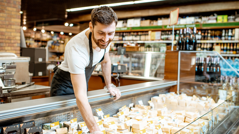 employee arranging cheese section