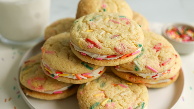 Birthday cake cookie sandwiches stacked on plate