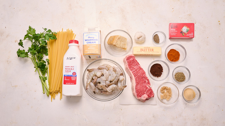 Steak and shrimp Alfredo ingredients on marble counter