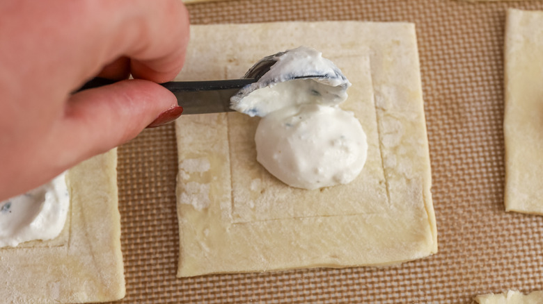 Cheese filling on top of a pastry square