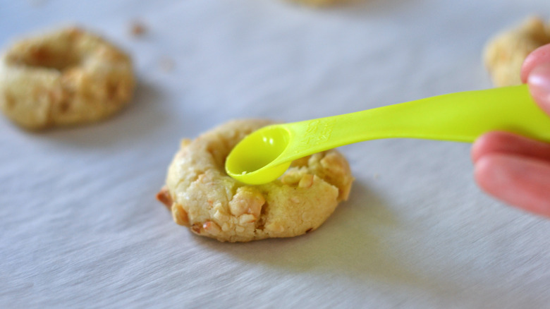 Re-pressing indents in hazelnut thumbprint cookies