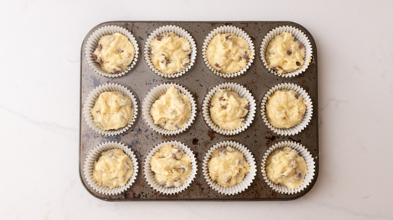 Unbaked banana chocolate chip muffins in tin