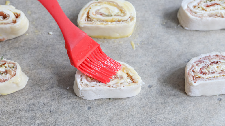 brushing egg wash on pinwheels 