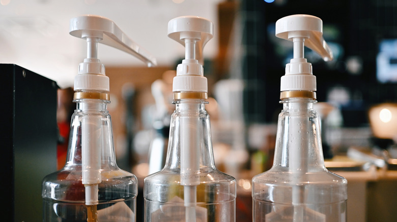 A close up picture of three coffee syrup bottles.