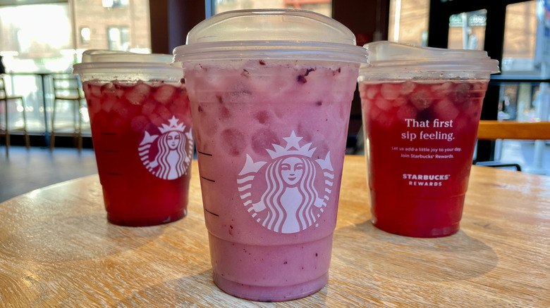 Starbucks Midnight Drink Refresher in front of the other Blackberry Sage Refresher options on a table