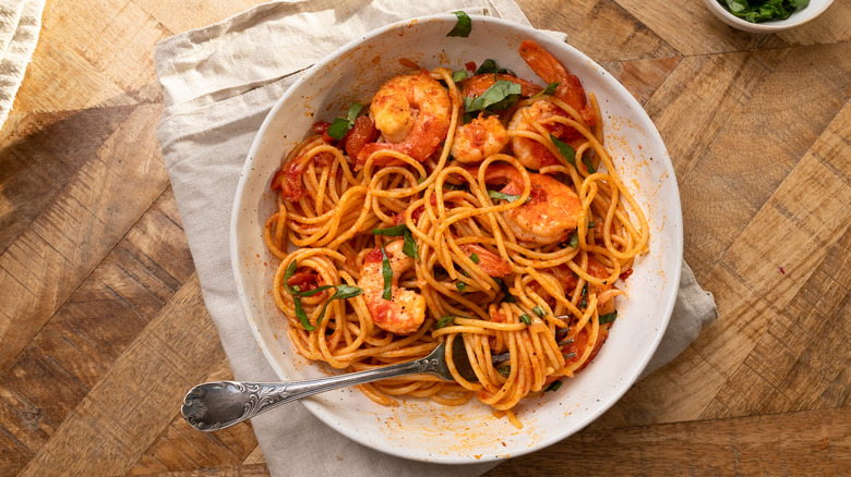 Garlic shrimp pasta in white bowl with fork
