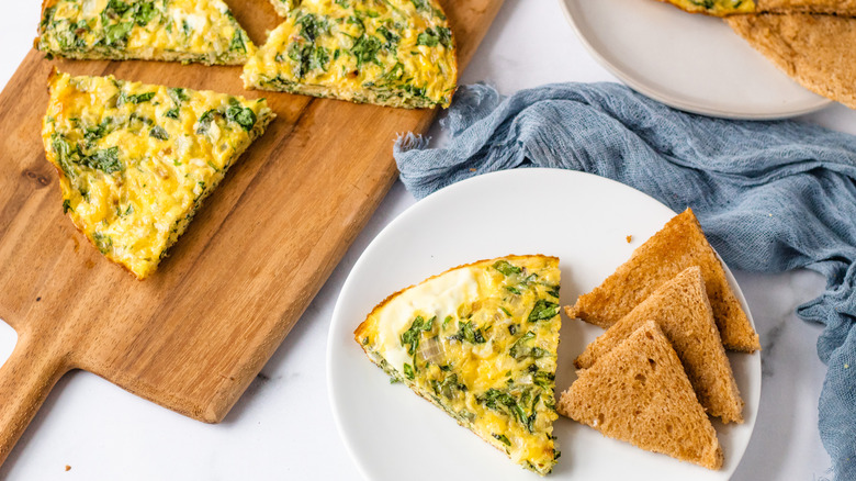 quiche servings on wooden board with bread