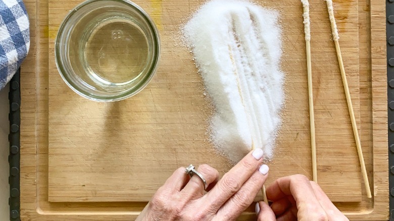 wooden skewers and sugar on board