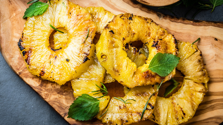 grilled pineapple with mint on a wooden board