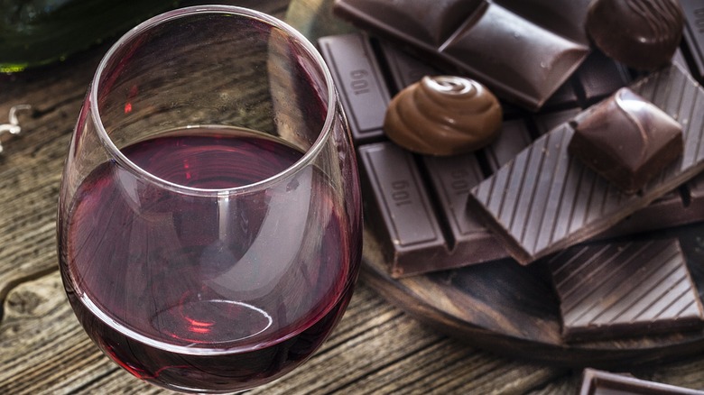 Overview of a glass of red wine with various chocolates