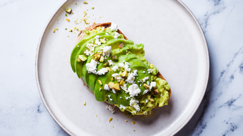 Avocado toast on a plater with feta and seeds