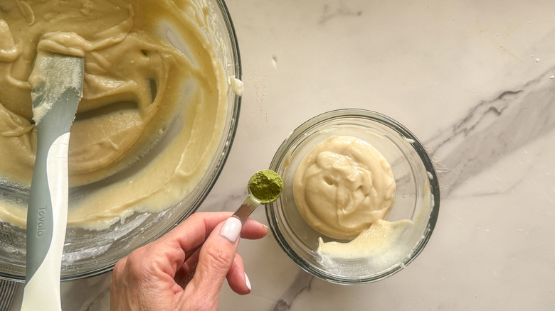 hand adding matcha to frosting