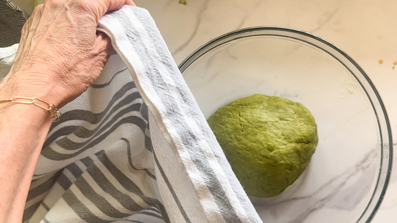 hand covering bowl with towel