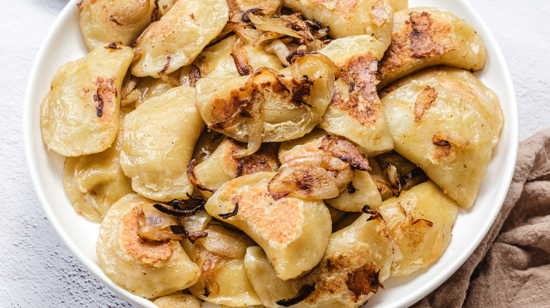 Plate with close up on fried pierogies with onions