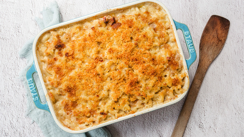 Lobster mac and cheese casserole dish with wooden spoon