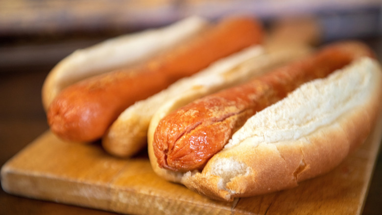 two hot dogs on wood board