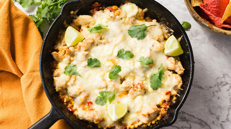 Close up on skillet of cheesy street corn and chicken casserole