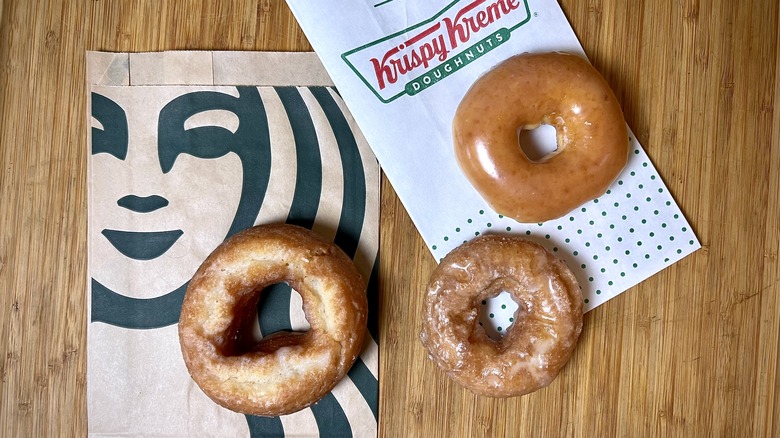 Starbucks and Krispy Kreme doughnuts on a wooden cutting board