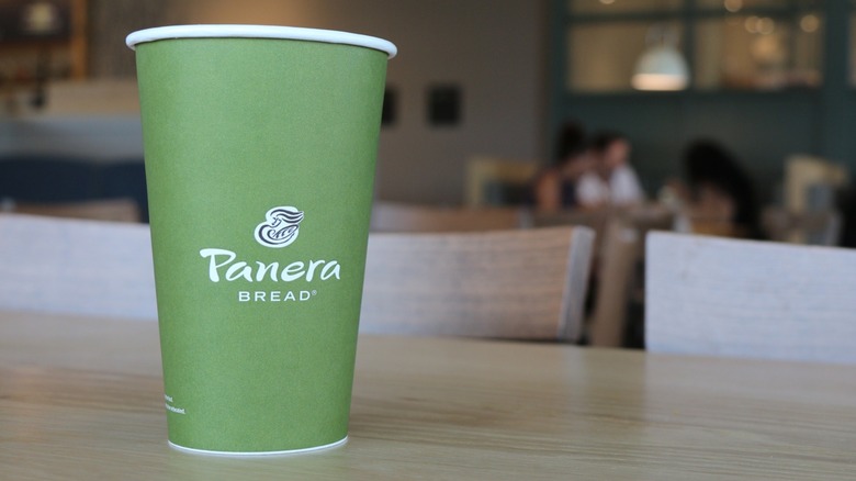 A green paper Panera cup on a table