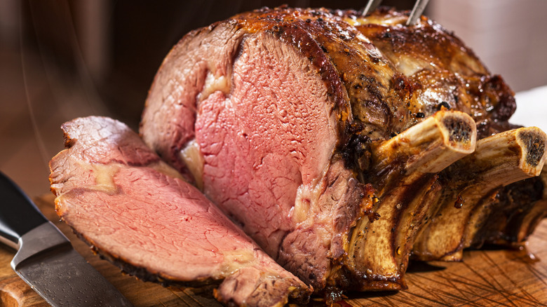 A cooked, bone-in prime rib being carved