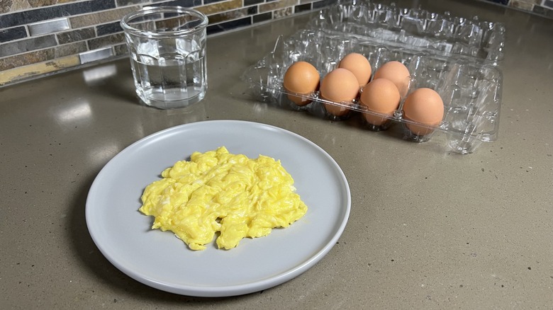 Scrambled eggs beside water glass