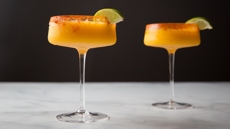 Frozen mango margaritas on table