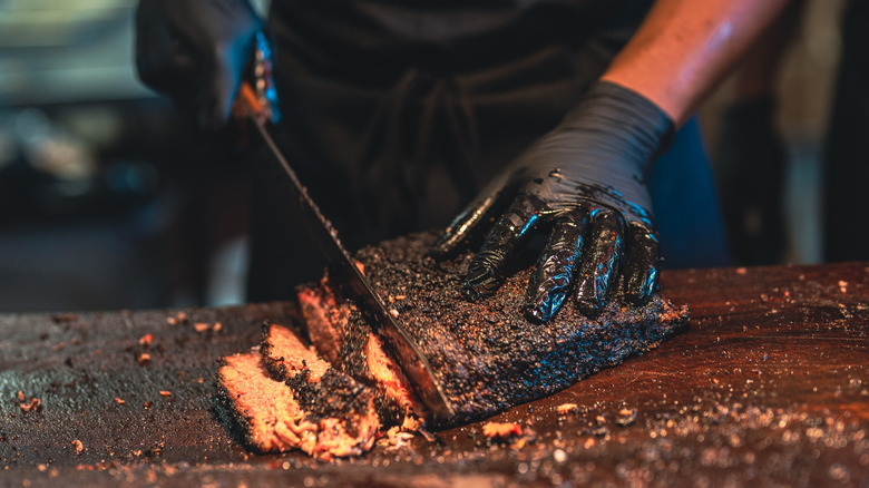 A chef slices into a barbecue brisket