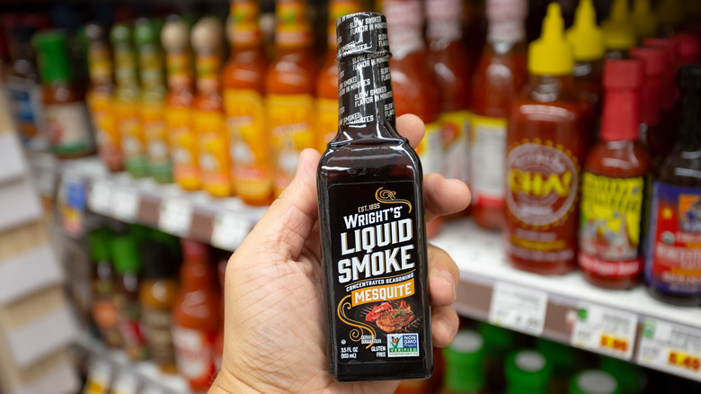 hand holding bottle of Wrights liquid smoke